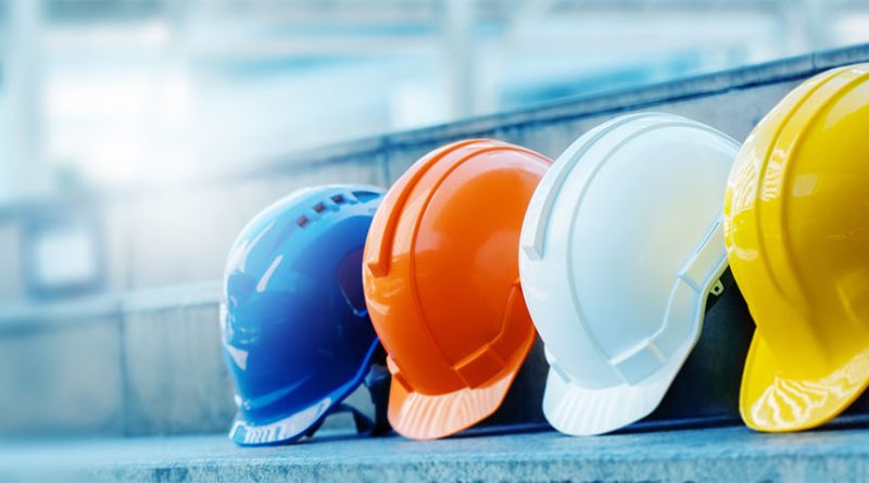 Image of four different colored safety hats lined up in a row to support safety helmets article.