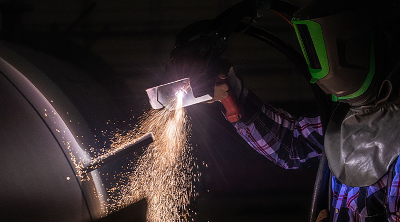 Construction worker in protective clothes working on equipment to support Apache Industrial article