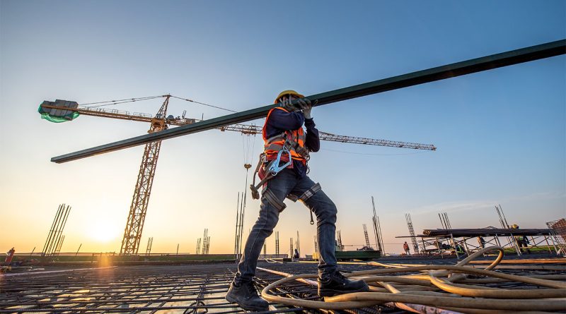 Construction worker carrying materials on site to support delays article