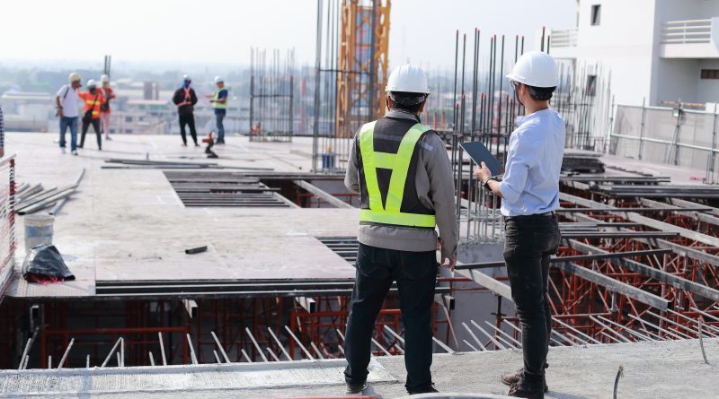Two engineers work on the construction site. They are checking the progress of the work.