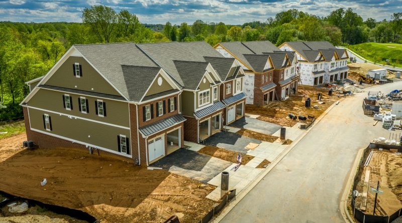 Elevated view of almost finished luxury townhouses with two single car garages, brick and shake and shingle siding