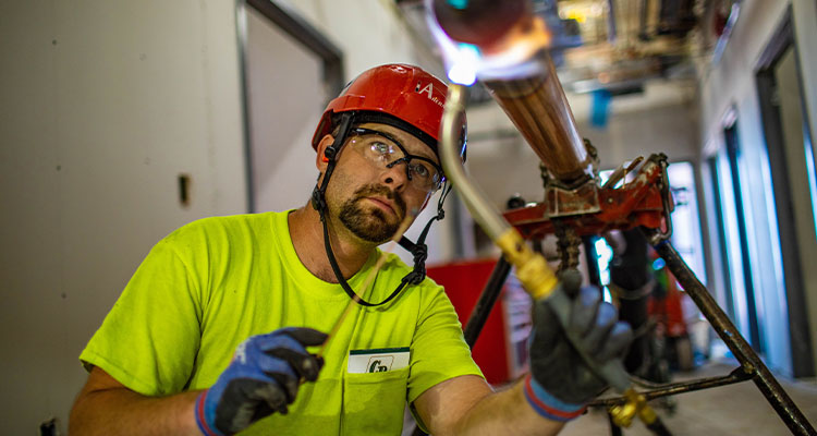 a pipefitter or plumber, working on a piping system