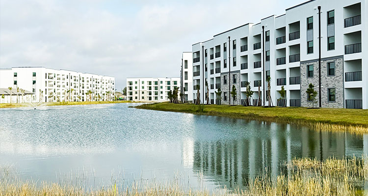 Estero Vista Apartments, a residential community featuring modern buildings set around a body of water