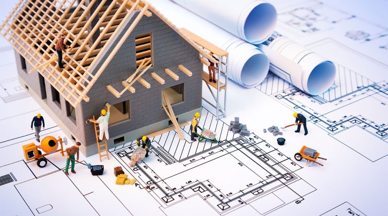 housing construction model with blueprints and plastic home