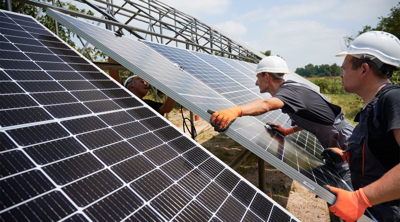 Solar panels in the California desert with mountains in the background.