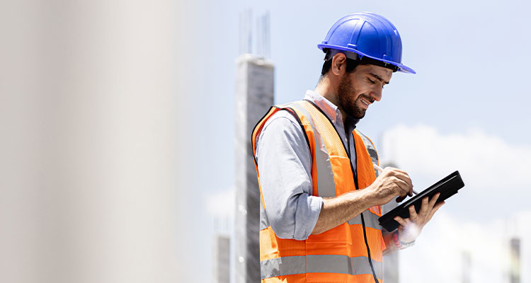 a construction worker or site manager using a tablet computer on a construction site
