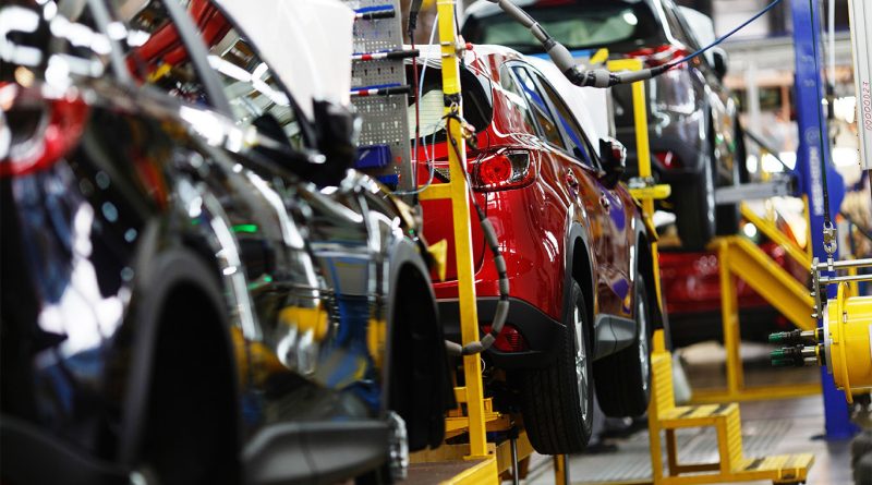 Automotive factory floor with workers retooling existing production lines in the US.