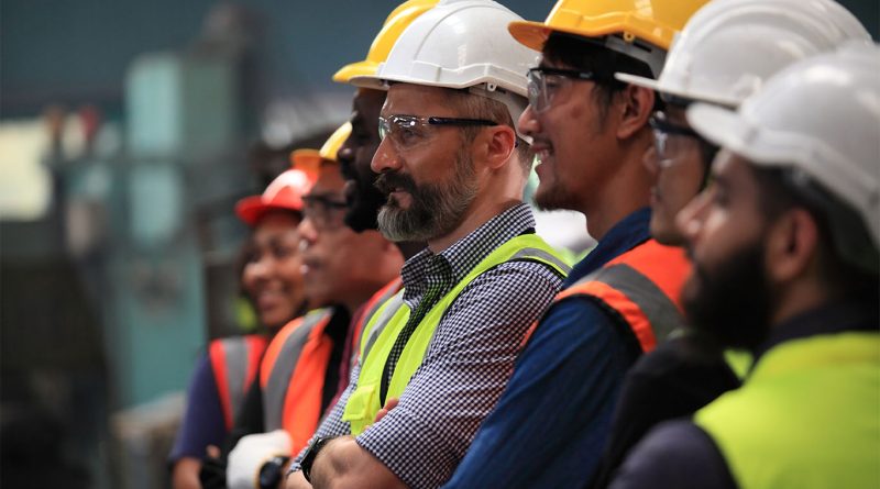 Construction workers at a job site with cranes and unfinished buildings in the background, representing a slowing labor market
