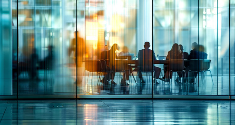 a group of professionals engaged in a business meeting inside a modern conference room with glass walls and ambient lighting
