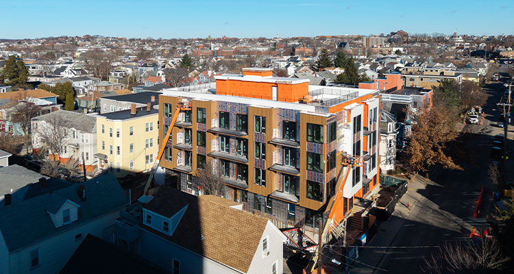a multi-story residential building currently under construction within a densely populated urban neighborhood