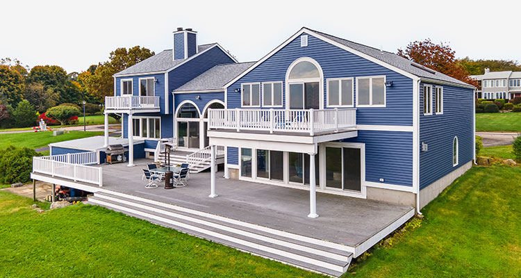 a large, two-story residential house with a blue exterior and white trim