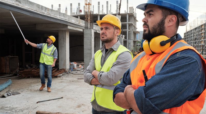 Construction workers operating equipment and installing electrical and HVAC systems on a US job site
